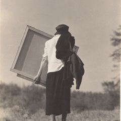 Georgia O'Keeffe carrying canvas. 